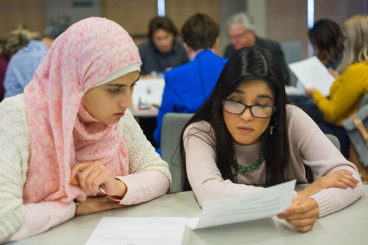 Two female students looking over informational material.